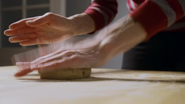 Woman rolls out ginger dough with a rolling pin