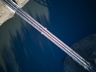 Aerial view of steel underspanned suspension railway bridge over Bobr River in Pilchowice, Wonderfull lake with islands and green forests in mountains on a early spring day in Pilchowice, Poland © Robert