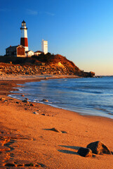 Waves from the ocean and sea gently roll onto the beach and shore near the Montauk Point Lighthouse