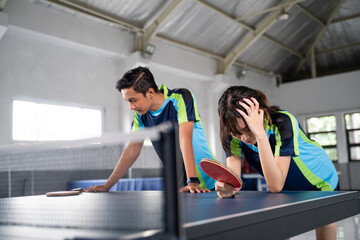 Asian ping pong doubles players get frustrated when they lose a ping pong match