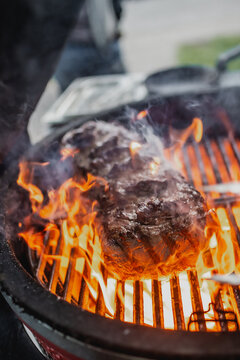 Grilling medium rare steak in a fire grill. Vertical photo