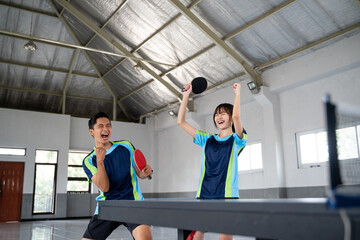 male and female ping pong players happy to score in ping pong match