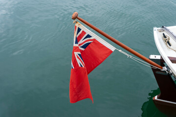 Fototapeta na wymiar Red Ensign flag on the stern of a sailing boat.