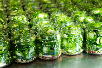 Fresh jalapeno peppers in jars close up. Preparation for conservation. Homemade canned vegetables.
