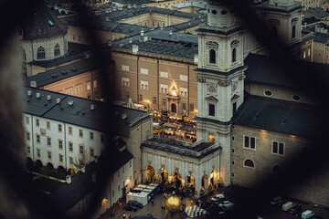 Naklejka premium Aerial shot of Christmas market in Domplatz, Salzburg, Austria, from Fortress Hohensalzburg at dusk - wide