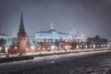 Moscow, Russia - December 27, 2022: Tower of the Moscow Kremlin. Cold and deserted Moscow street on a snowy winter evening near Red Square - 557464332