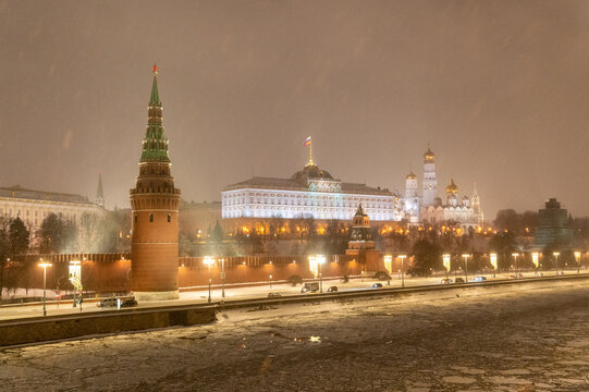 Moscow, Russia - December 27, 2022: Tower of the Moscow Kremlin. Cold and deserted Moscow street on a snowy winter evening near Red Square