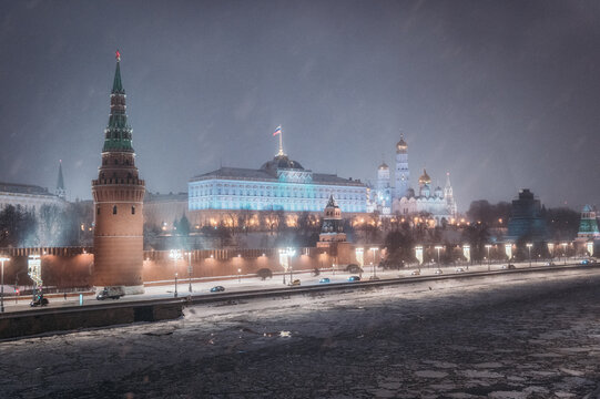 Moscow, Russia - December 27, 2022: Tower of the Moscow Kremlin. Cold and deserted Moscow street on a snowy winter evening near Red Square