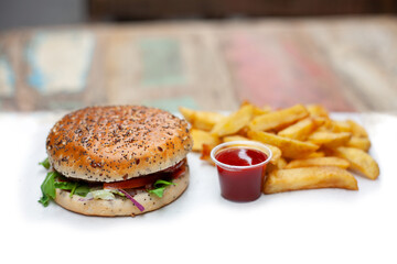 Tasty, fresh hamburger with french fries on a white table unhealthy food
