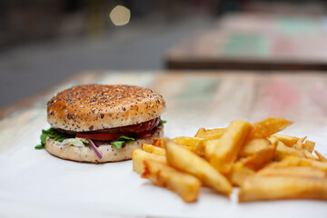 Tasty, fresh hamburger with french fries on a white table unhealthy food