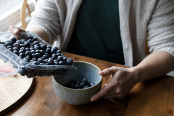Person pouring berries into a bowl. © annie