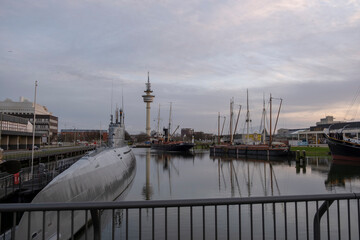 Fototapeta premium Sunset in Bremerhaven with houses and ships and the (bremer Schiffahrts-Museum), Klimahaus and the coast line of Bremerhaven (technik museum) taken from 90 m high bulding, Monochrom, sepia, panorama 
