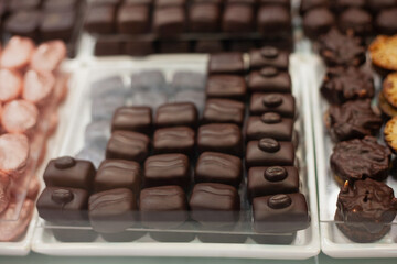 Delicious sweets and cookies made of black and brown chocolate on the festive table