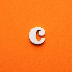 c white lowercase letter - Background in orange foamy