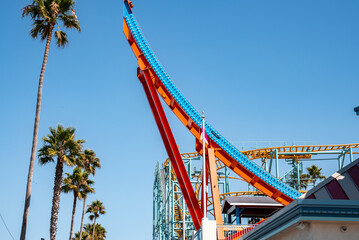 Santa Cruz, USA. September 20, 2022. Low angle view of shockwave ride and palm trees growing at Santa Cruz Beach Boardwalk with clear blue sky in the background on sunny day