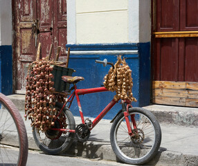 Old, red bike on the road with onions sustainable.  