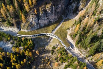 Aerial view of an avalanche protection barrier on a mountain road in the Dolomites in autumn