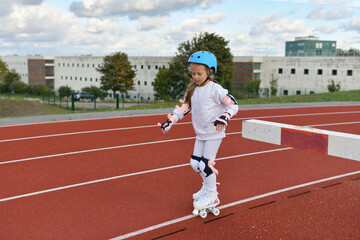Obraz premium A girl in vintage white roller skates and a helmet at the stadium
