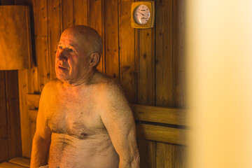 Older man over 60 sweats in steam sauna for health . High quality photo