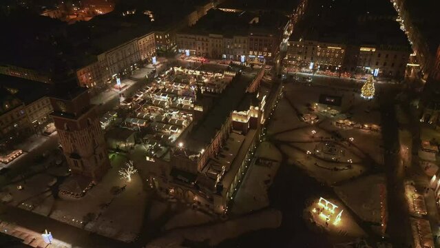 Aerial view of Rynek Glowny in Krakow in winter at night, Poland. It is winter and snow on the Main square.