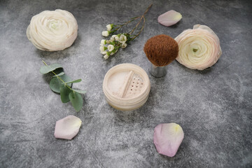             Natural homemade face loose powder with blush (powder brush) on grey marble background with eucalyptus leaves and flowers.   