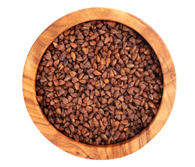 Buckwheat tea in wooden bowl, isolated on white background. Whole roasted buckwheat grains. Fagopyrum tataricum. Top view.