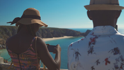 Young beautiful African siblings in vacation in Cornwall united kingdom taking photos of surrounding    