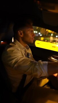 Businessman driving car in night city