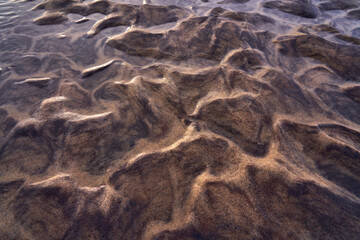 the sun bounces off of a sandy shoreline