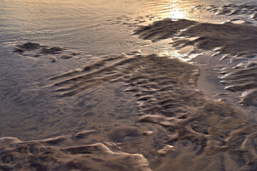 the sun bounces off of a sandy shoreline