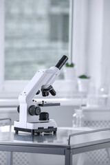 Modern medical microscope on metal table in laboratory
