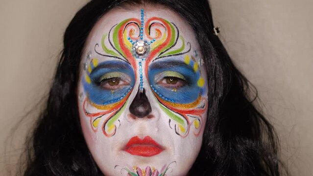 Closeup of Woman Wearing Day of the Dead Catrina Makeup with Black Hair, open and closed eyes