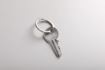 House key on light grey background. Real estate agent services