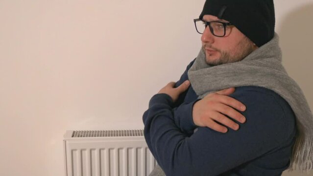 Side Portrait Of A Guy In Winter Clothes Feeling Cold At Home. medium shot