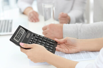 Woman counselling mature couple about their budget plan in office, closeup