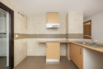 Newly fitted open plan kitchenette with wooden cabinets and appliances that need to be integrated