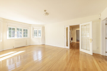 Empty living room with French oak hardwood floors, white lacquered wood door joinery with...