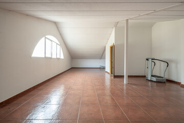 A large empty living room of a detached house in the attic with sloping ceilings