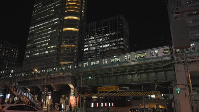 This video show a train passing through Akihabara cityscape at night time in Japan.