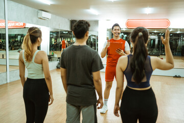 Fototapeta premium woman in sportswear asks by raising her hand during a briefing with an instructor before exercising