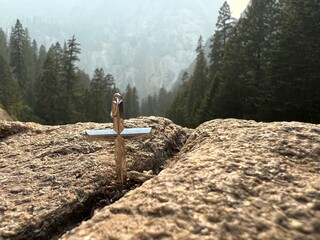 Golden Cross & Chain standing in front of a cliff