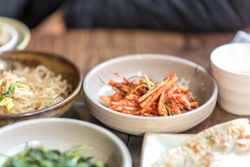 Assortment of Korean food in a Korean traditional restaurant. Unknown vegetables with spicy saurce.