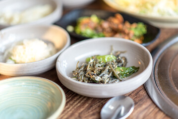 Assortment of Korean food in a Korean traditional restaurant. Fried anchovy with vegetables and sesames.