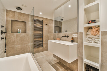 a modern bathroom with beige tiles and white fixtures on the walls, along with a glass shower stall...