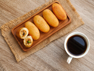 Combro indonesian traditional food in wooden tray and cup of coffee , combro made of processed cassava root.