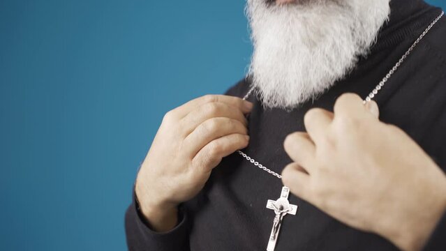 The Christian man wears the necklace of the cross around his neck, which means he believes in Jesus Christ. God bless you.