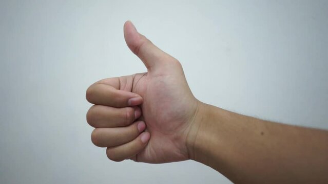 Man hand showing thumb up as a good compliment gesture in white isolated background