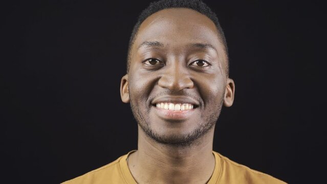 Close-up portrait of smiling friendly african young man.
Friendly optimistic african young man looking at camera and smiling.
