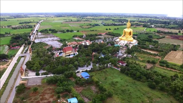 Footage of Impressive Aerial View of a Massive Golden Seated Buddha Image at Wat Muang Temple, Ang Thong Province, Thailand