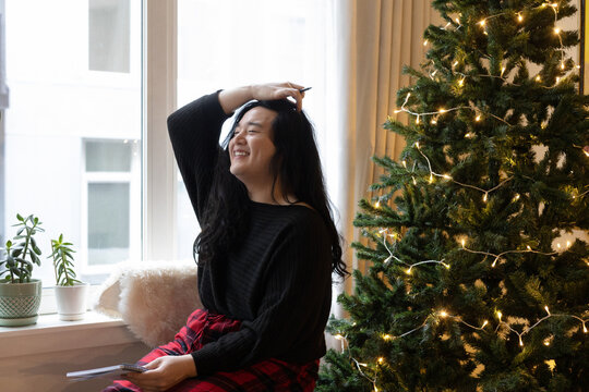 Asian American trans woman decorating for the holidays.
